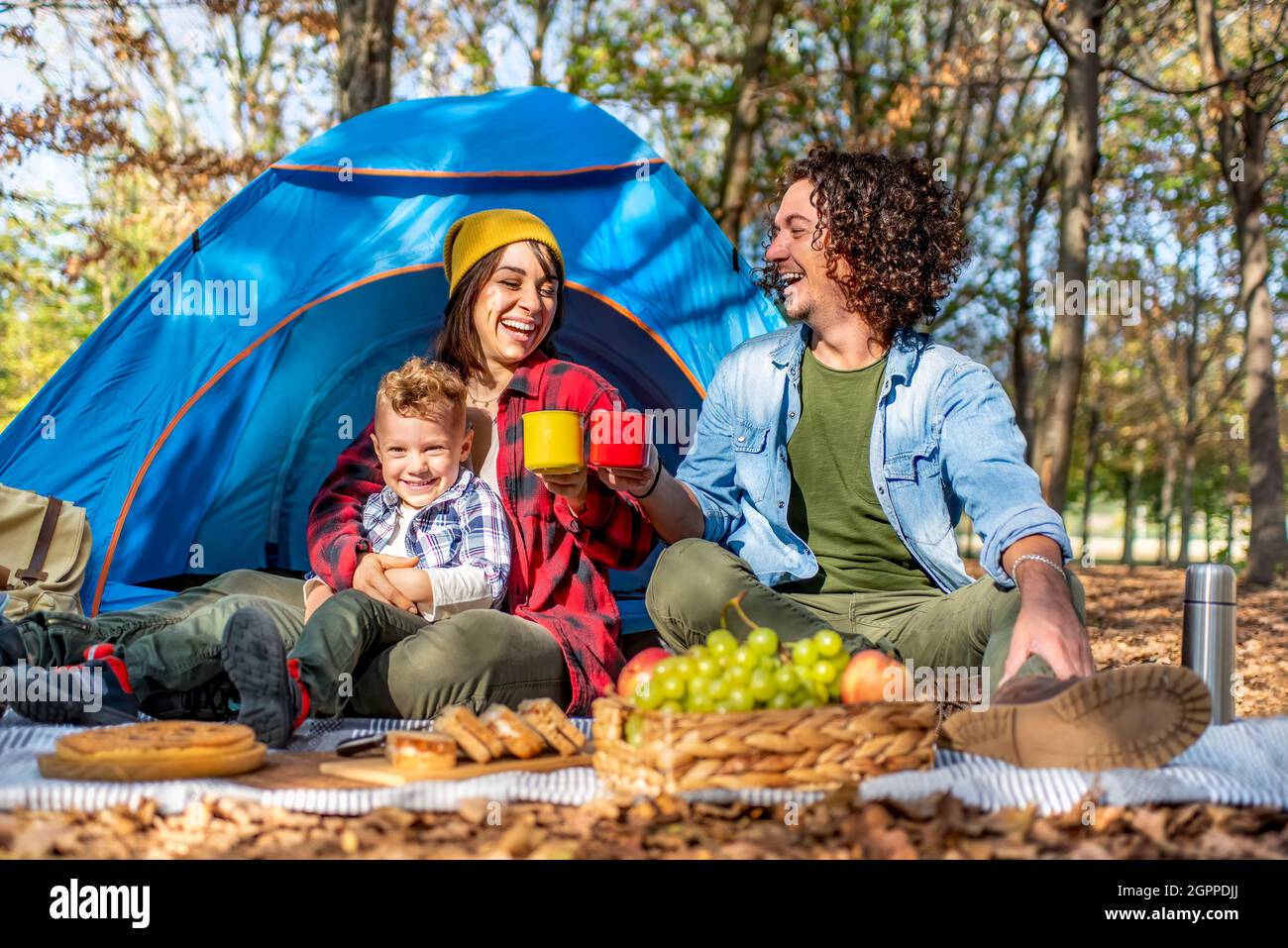 Junge glückliche Familie Camping im Freien mit Zelt im Herbst Natur. Mama,  Papa und kleines Kind mit einem Picknick in die Wildnis. Menschen, die  einen Toast Stockfotografie - Alamy