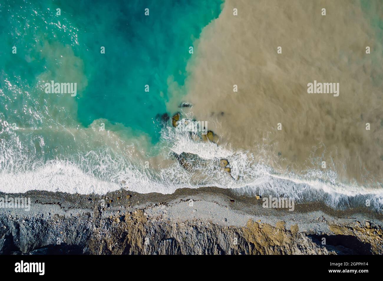 Luftaufnahme der Meeresoberfläche mit Wellen, schmutzigem Wasser und Küstenlinie Stockfoto