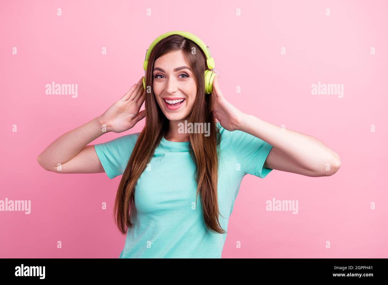 Foto von charmanten aufgeregt junge Frau gekleidet türkis T-Shirt-Kopfhörer Musik lächelnd isoliert rosa Farbe Hintergrund hören Stockfoto