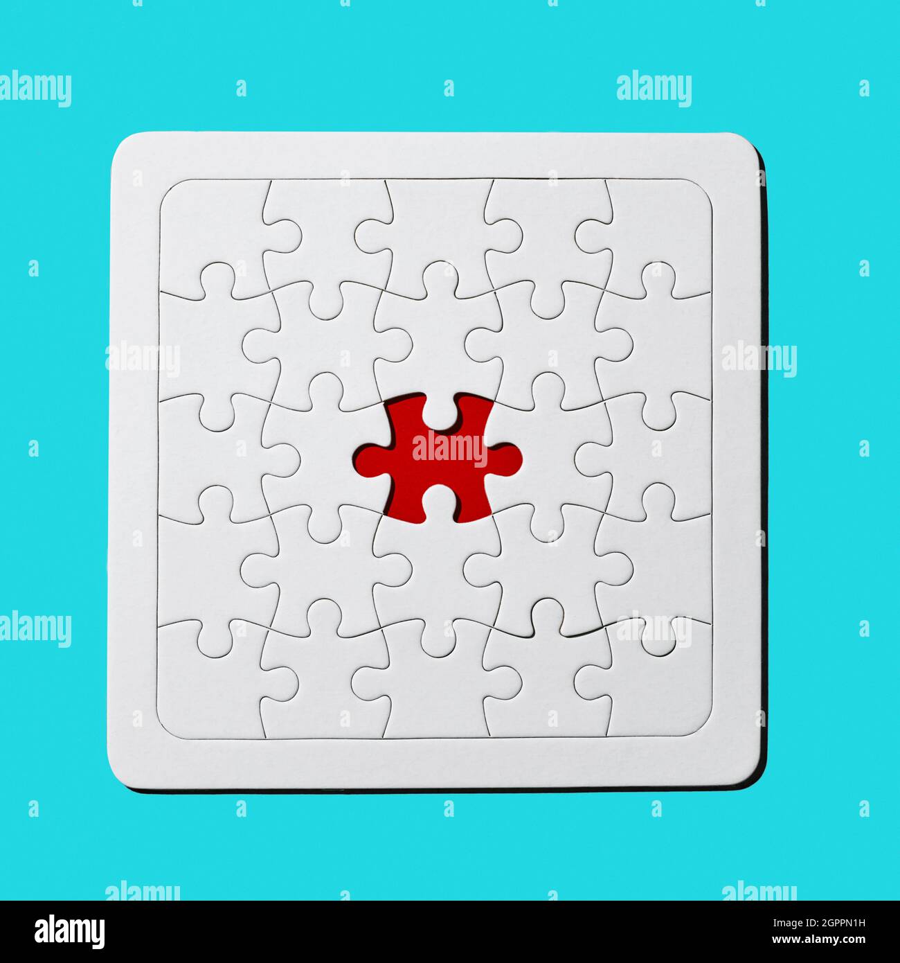 Eine rote Lücke in einem leeren weißen Puzzle fehlt ein Stück auf blauem Hintergrund Stockfoto