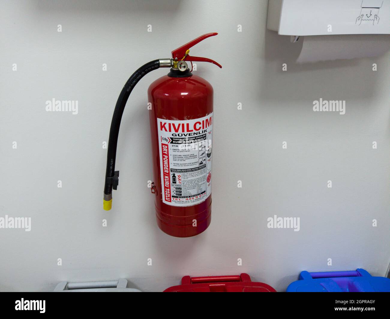Feuerlöscher an der grauen Wand an öffentlichem Ort mit türkischem Etikett und Gebrauchsanweisung. Marmaris, Türkei - 6. September 2021. Stockfoto