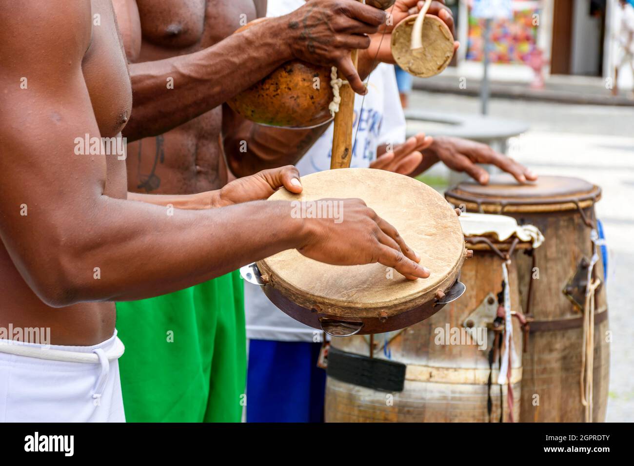 Musiker spielen typische Instrumente afrikanischer Herkunft, die in Capoeira und anderen brasilianischen Kulturveranstaltungen nas ruas de Salvador na Bahia verwendet werden Stockfoto