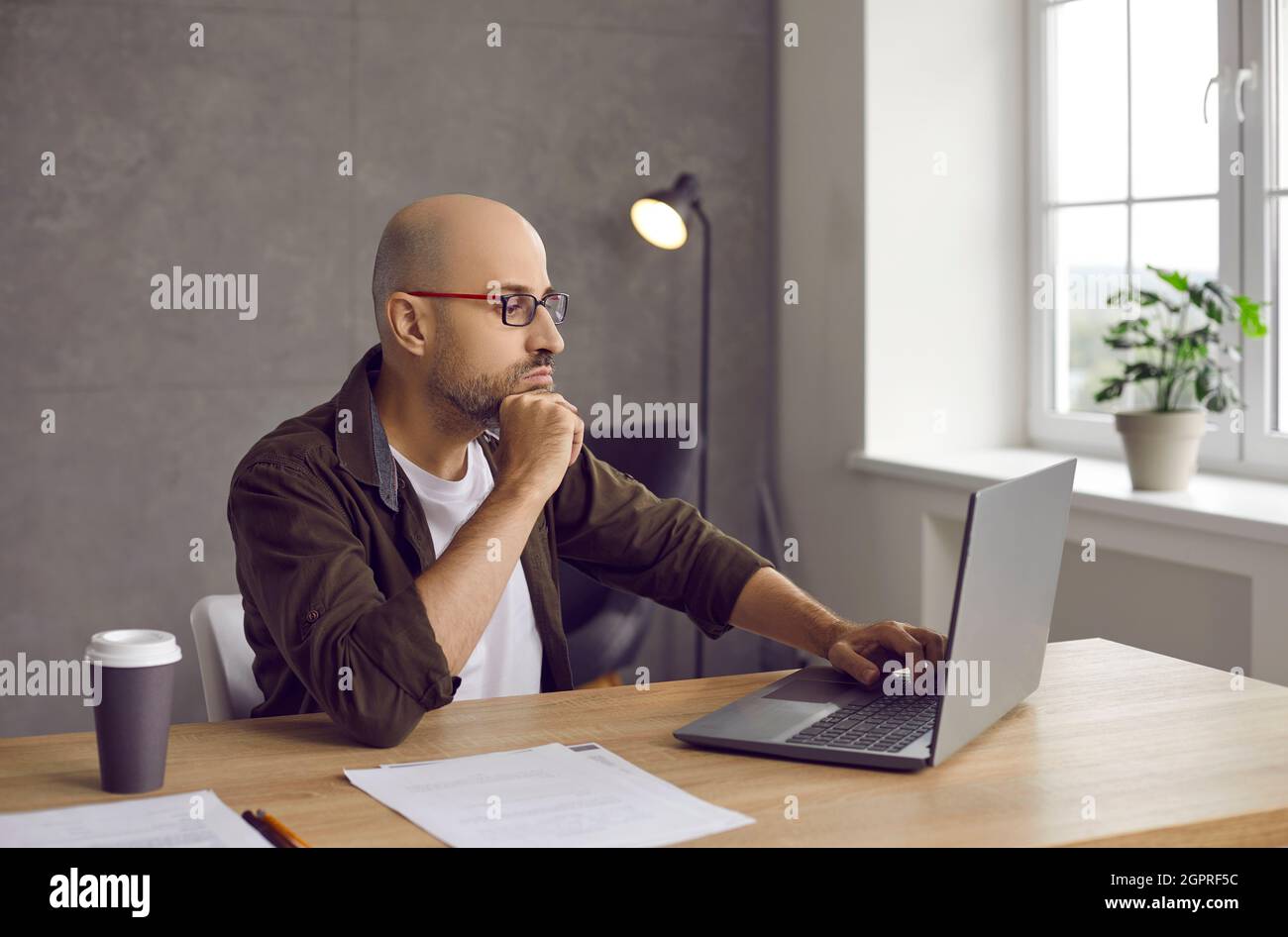 Junge kaukasische Mann arbeiten online am Computer zu Hause Stockfoto