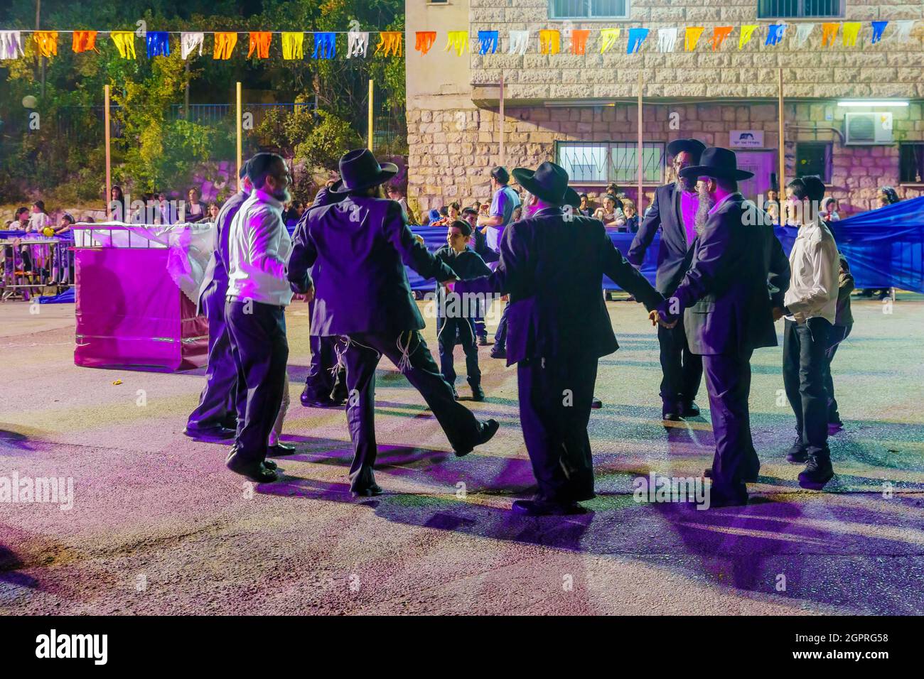 Safed, Israel - 28. September 2021: Jüdische Männer tanzen, Teil der Simchat-Tora-Tradition, Frauen sind hinter der Barriere, in Safed (Tzfat), Israel Stockfoto