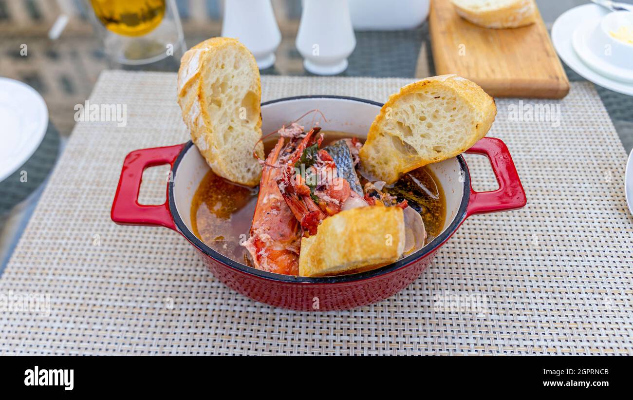 Fischsuppe und Knoblauchbrot in einer Schüssel auf einem Tisch serviert. Restaurant La Riviera im St Regis Nursultan Stockfoto