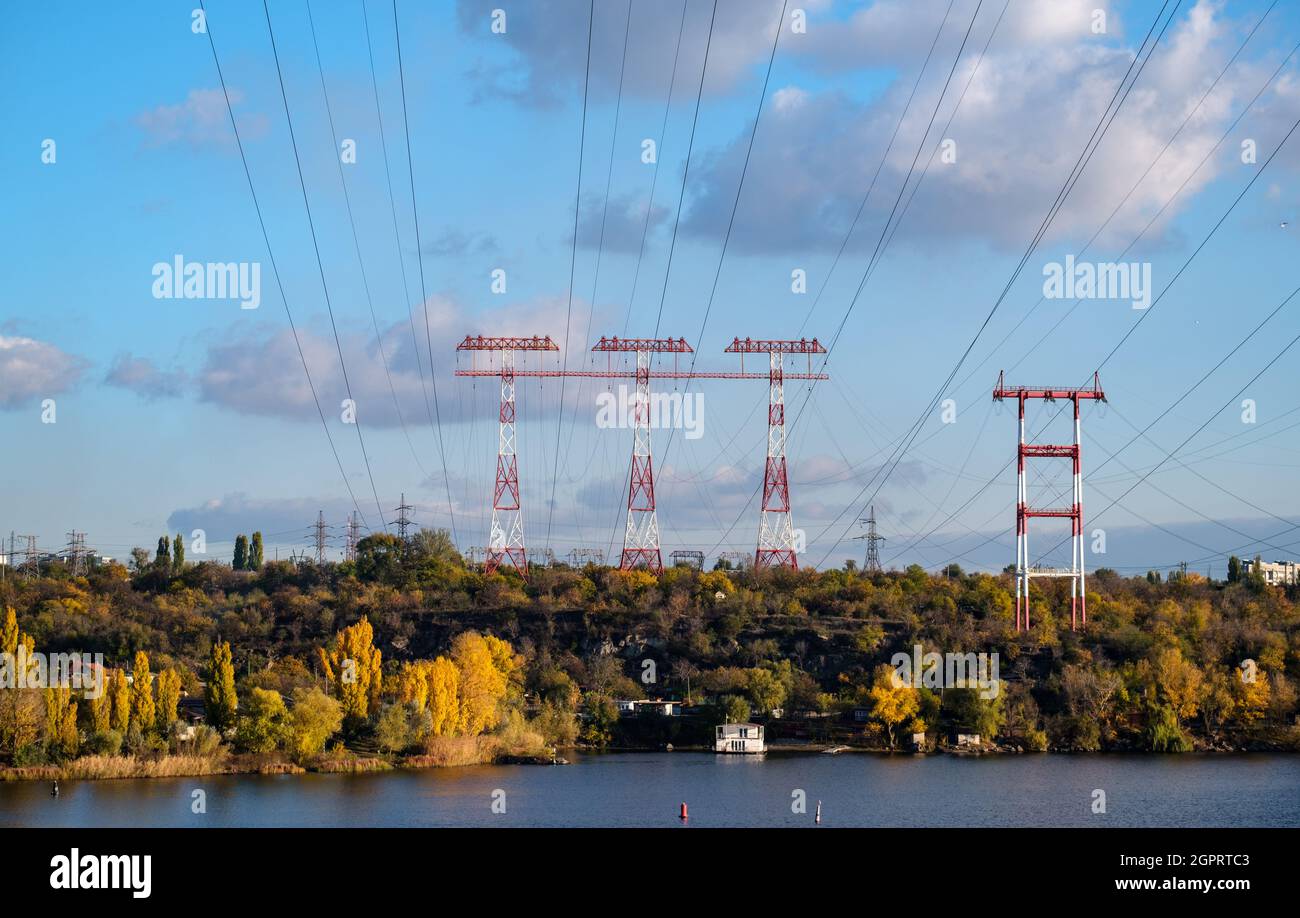 Hochspannungssäule, Freileitung, industrieller Hintergrund. Stromleitungen am Fluss Stockfoto