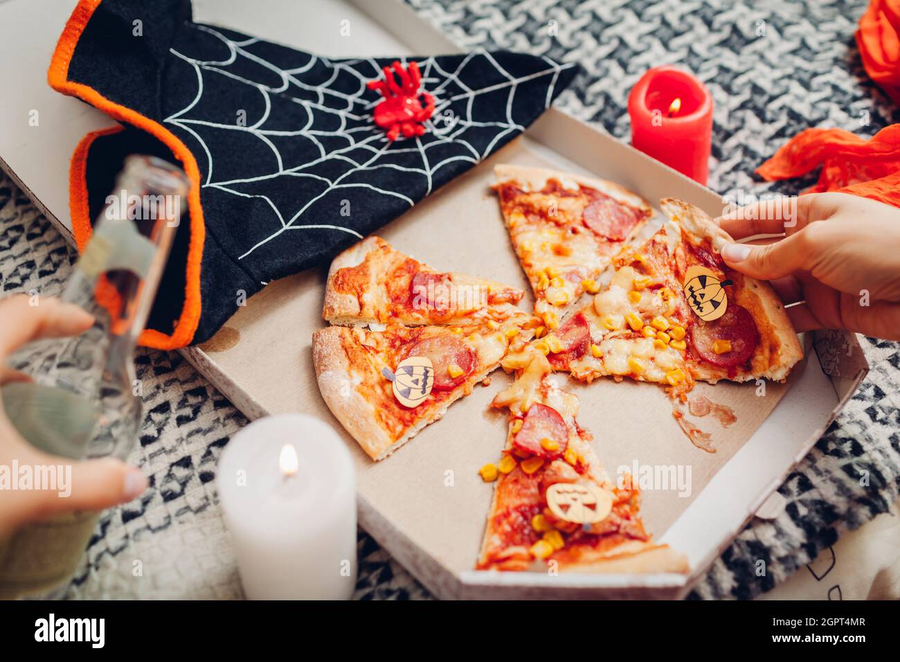 Helloween Pizza mit kleinen Papierkarren-O-Laternen-Kürbissen.  Feiertagsfeier mit Kerzen und Kostümen. Halloween Essen mit Getränk in der  Flasche Stockfotografie - Alamy