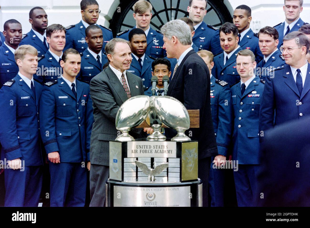 Washington, DC, USA. Mai 1996. US-Präsident Bill Clinton gratuliert Cheftrainer Fisher Berry, Left, während einer Zeremonie zur Übergabe der Trophäe „Commander-in-Chefs“ an das Fußballteam der Air Force Academy Falcons auf dem South Lawn des Weißen Hauses am 10. Mai 1996 in Washington, D.C.: Die Trophäe wird an den Gewinner des jährlichen Fußballspiels Air Force vs Army verliehen. Stockfoto