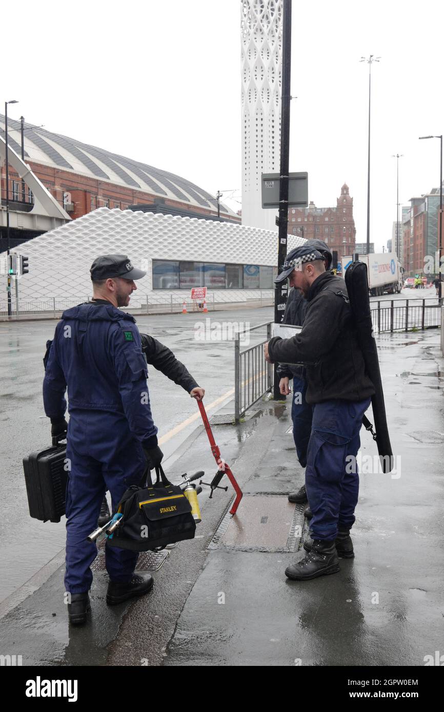 Manchester, Großbritannien. September 30 2021: Polizeibeamte heben Schachtabdeckungen als Teil der Sicherheit für die Konferenz der Konservativen Partei 2021 an. In ‘Manchester Central' in Manchester, Großbritannien. Die Teilnehmer werden im Midland Hotel übernachten.die Konferenz wird eine Mischung aus einer virtuellen Plattform sein. Die Konferenz wird zwischen dem 3. Und 6. Oktober stattfinden, wobei mehrere Proteste organisiert werden. Bildnachweis: Garyroberts/worldwidefeatures.com Bildnachweis: GARY ROBERTS/Alamy Live News Stockfoto