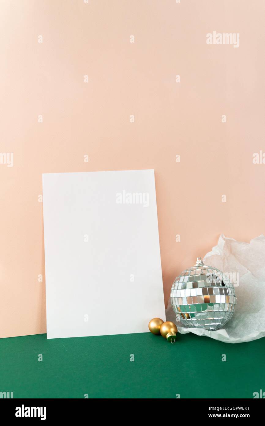 Retro-Stil Stillleben mit leerem Papier Mock-up und eingewickelte Disco-Ball auf rosa und grünen Hintergrund Stockfoto