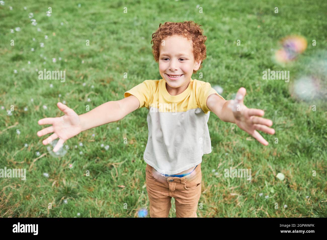 Porträt von niedlichen Jungen spielen mit Blasen im Freien im Park und lächeln, kopieren Raum Stockfoto