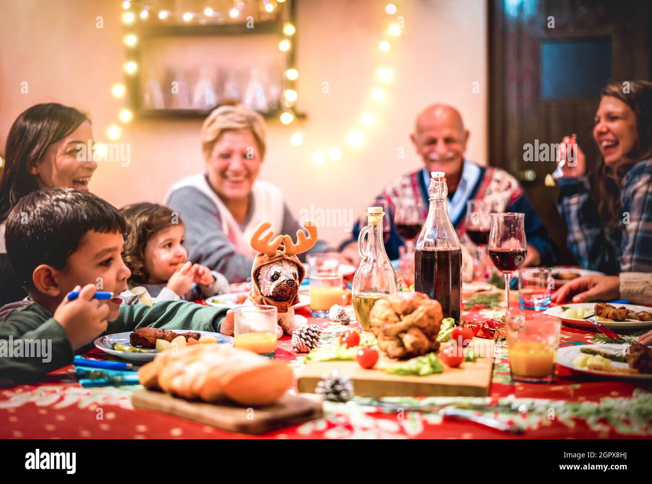 Multi Generation große Familie mit Spaß auf weihnachtsessen Party - Winterurlaub Weihnachten Konzept mit Großeltern und Kinder essen zusammen zu Hause Stockfoto