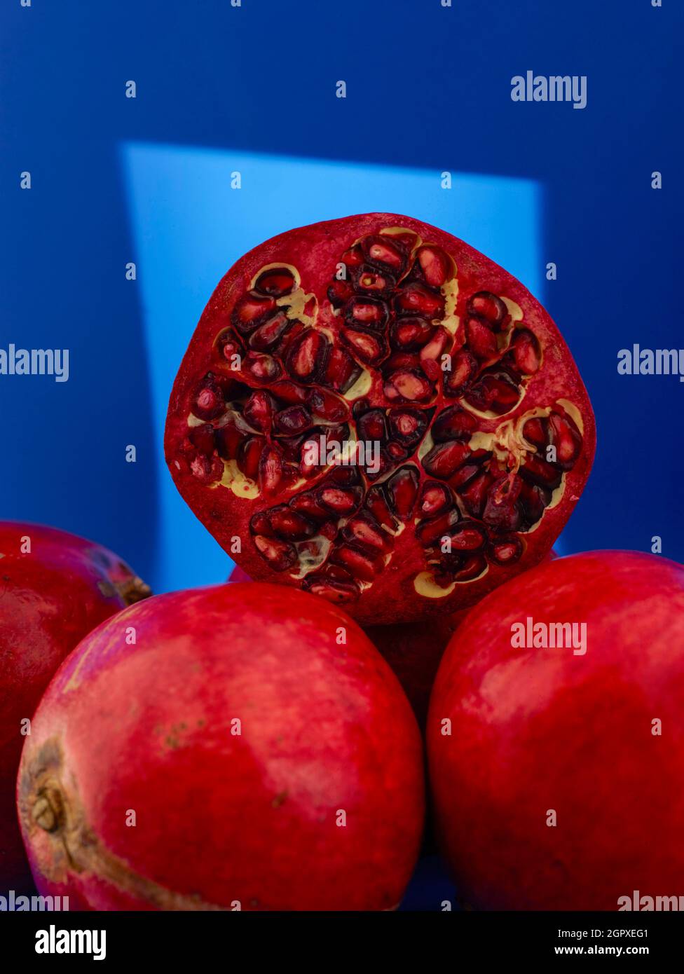 Granatapfel (Punica granatum), Fruchtstillleben vor farbigem Hintergrund Stockfoto