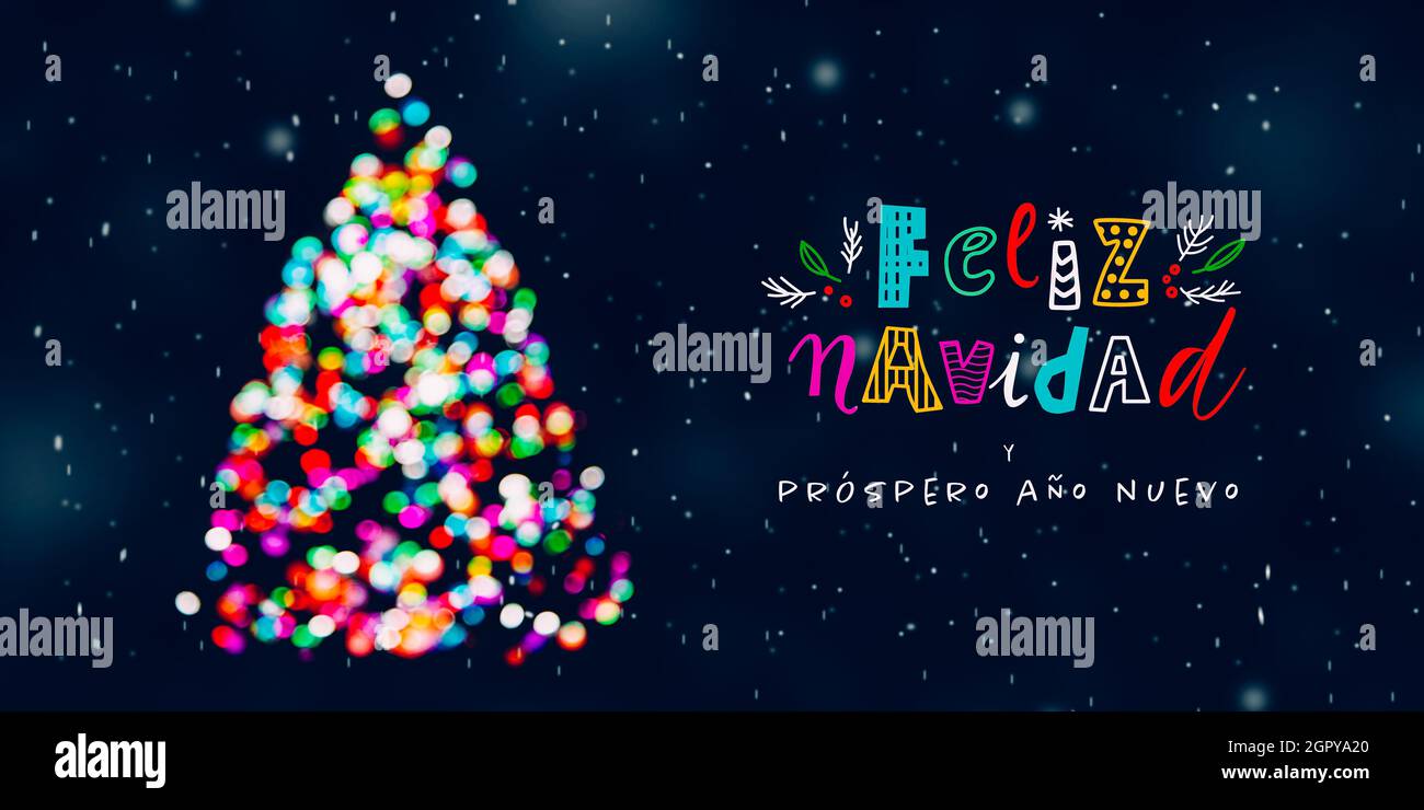 Feliz Navidad grüßt mit Weihnachtsbaum aus bunten, unfokussigen Weihnachtslichtern bei schneckender Nacht und lustigen Schriftzügen Stockfoto