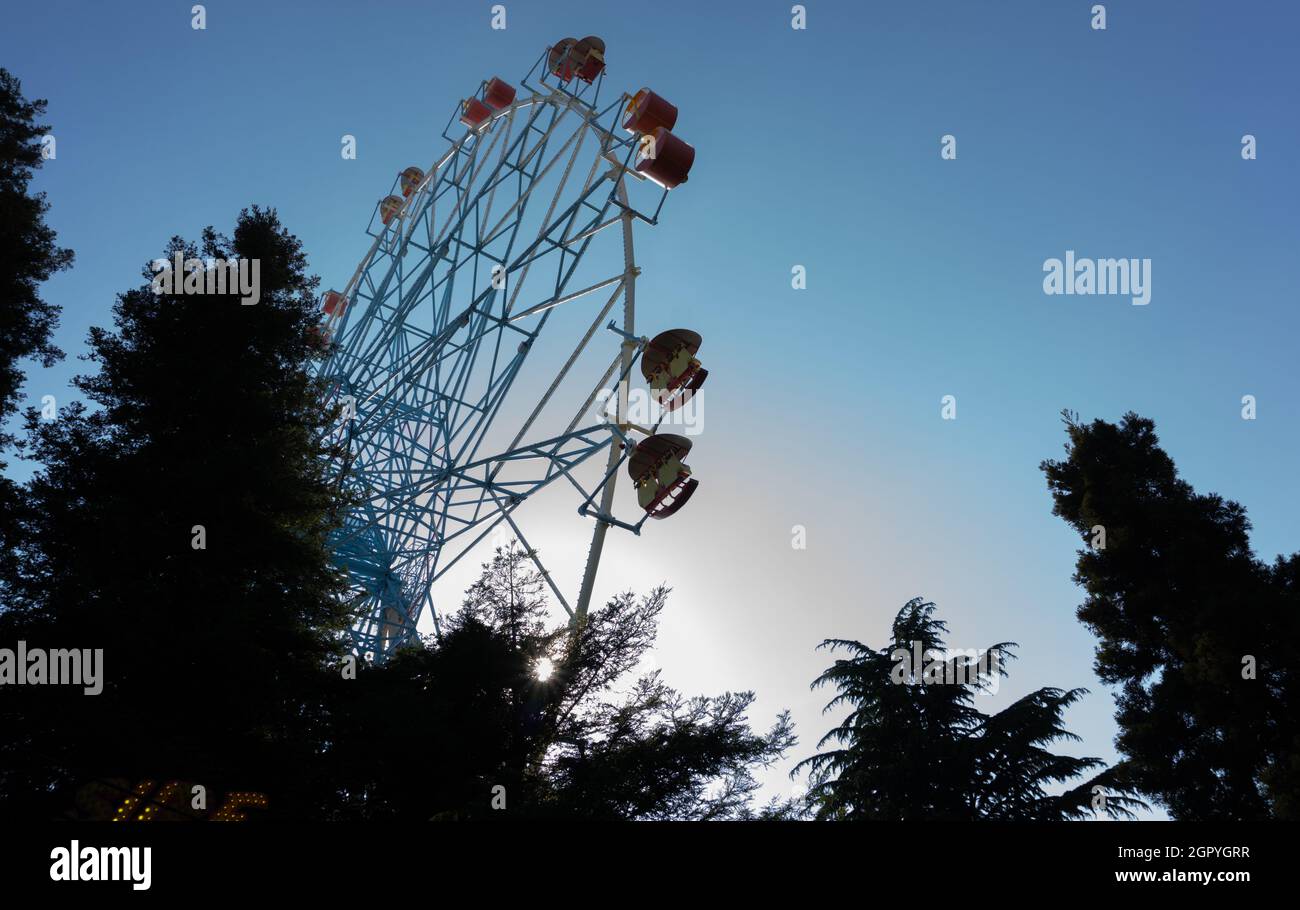 Farbenfrohe Riesenräder ragen gegen den Himmel bei Sonnenuntergang. Lazarevskoje, Sotschi, Russland, auf dem Rad die Inschrift Lazarevskoe Stockfoto