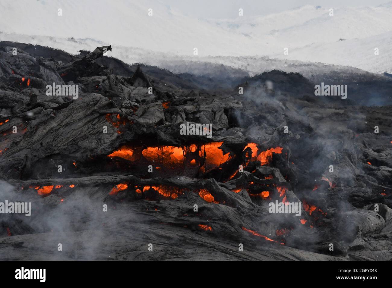 Lavafluss am Fagradalsfjall, Island. Die gekühlte Lavakruste ist schwarz, während die geschmolzene Lava rot und orange ist. Stockfoto