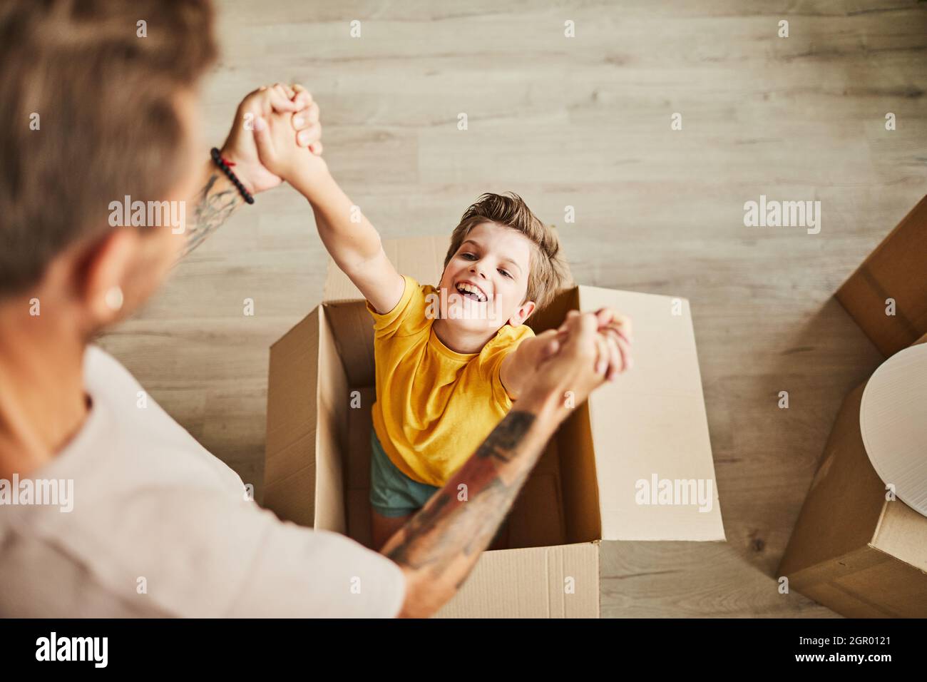 High-Angle-Ansicht auf Vater spielt mit niedlichen Jungen in Karton, während Familie in ein neues Haus, kopieren Raum Stockfoto