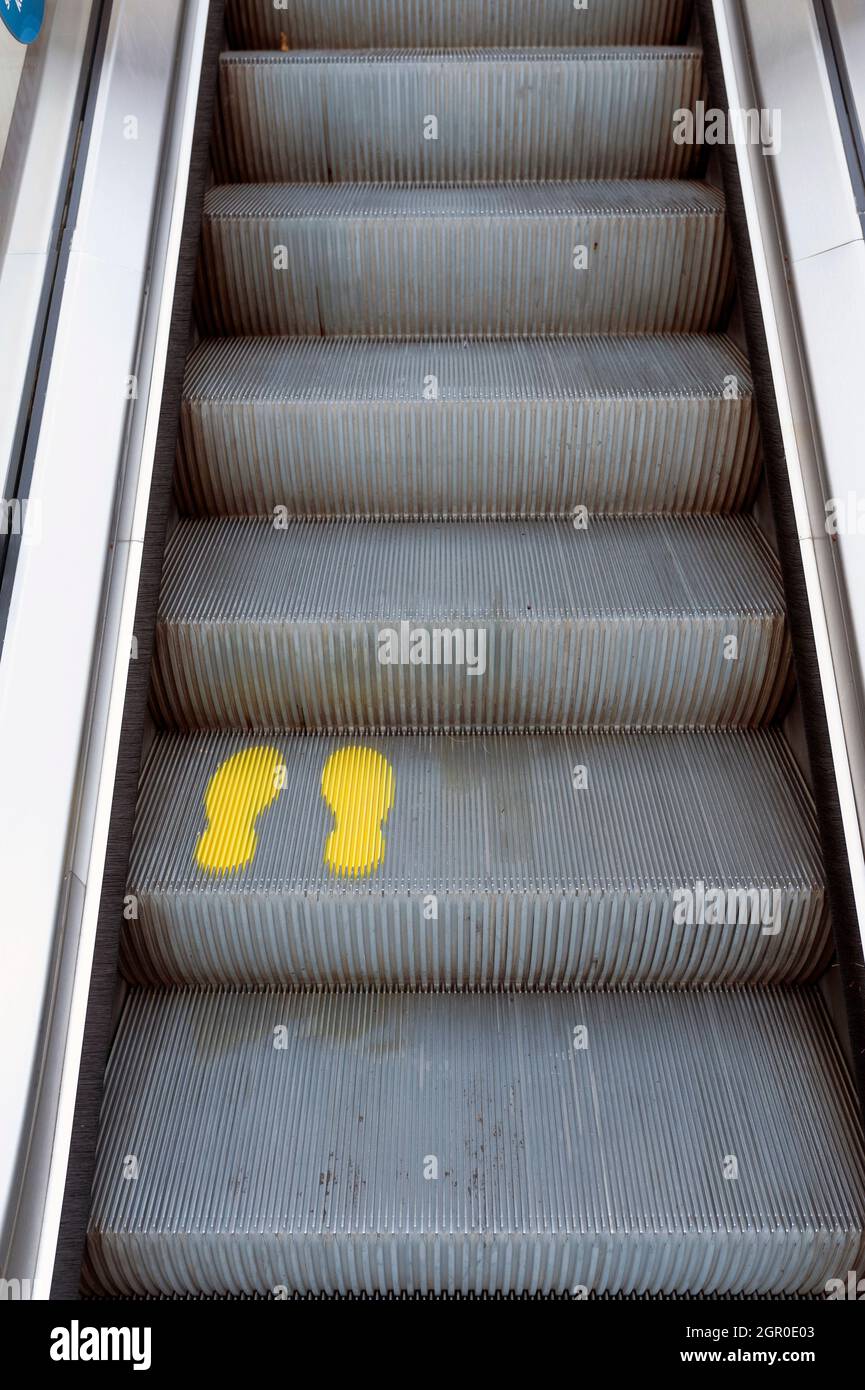 Gelbe Fußabdruck auf Rolltreppen Stockfoto