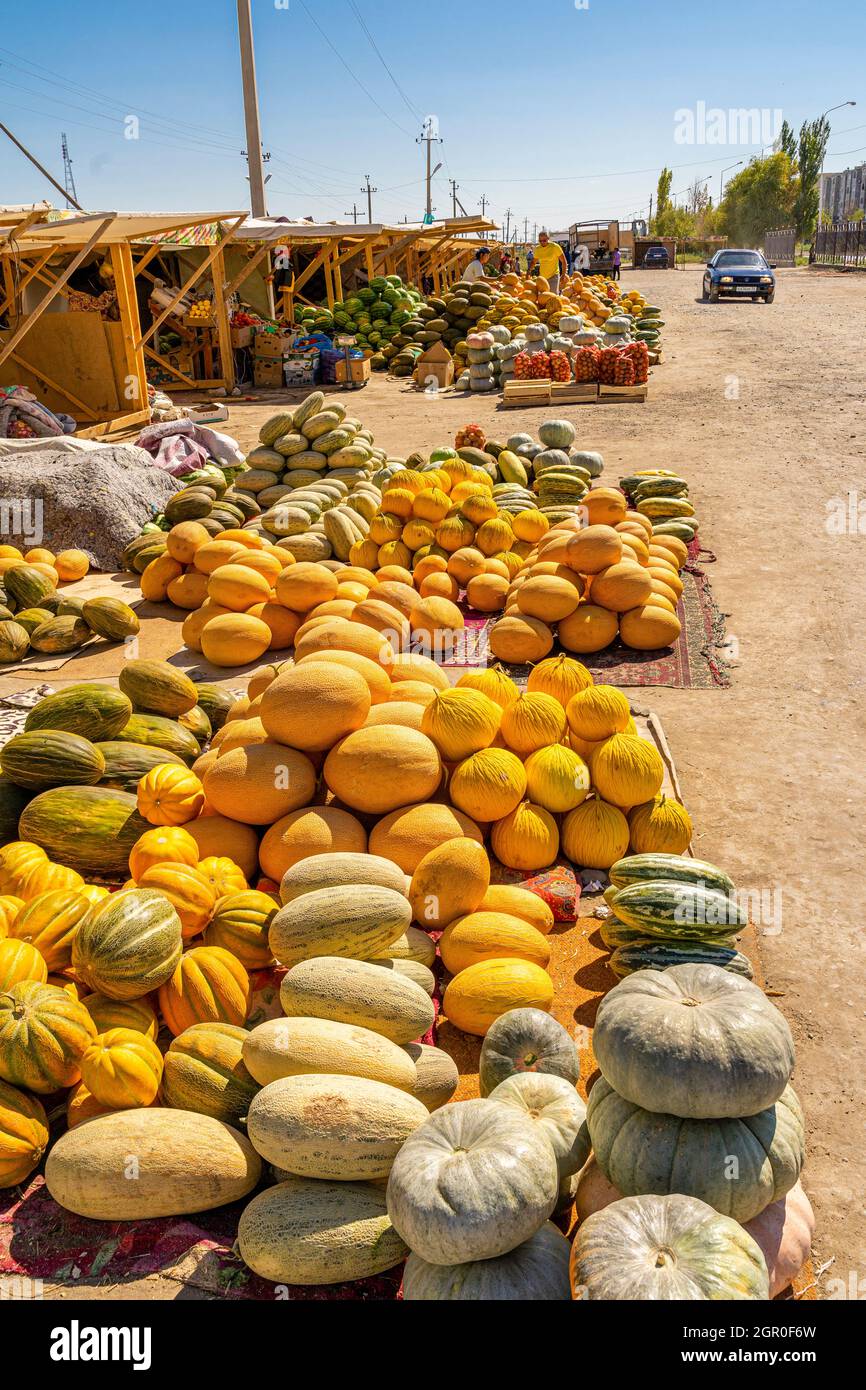Melonen und Kürbisse, die am Boden verkauft werden, werden auf dem saisonalen Outdoor-Markt in Kyzyl-Orda, Kasachstan, Zentral- und Asien ausgestellt Stockfoto