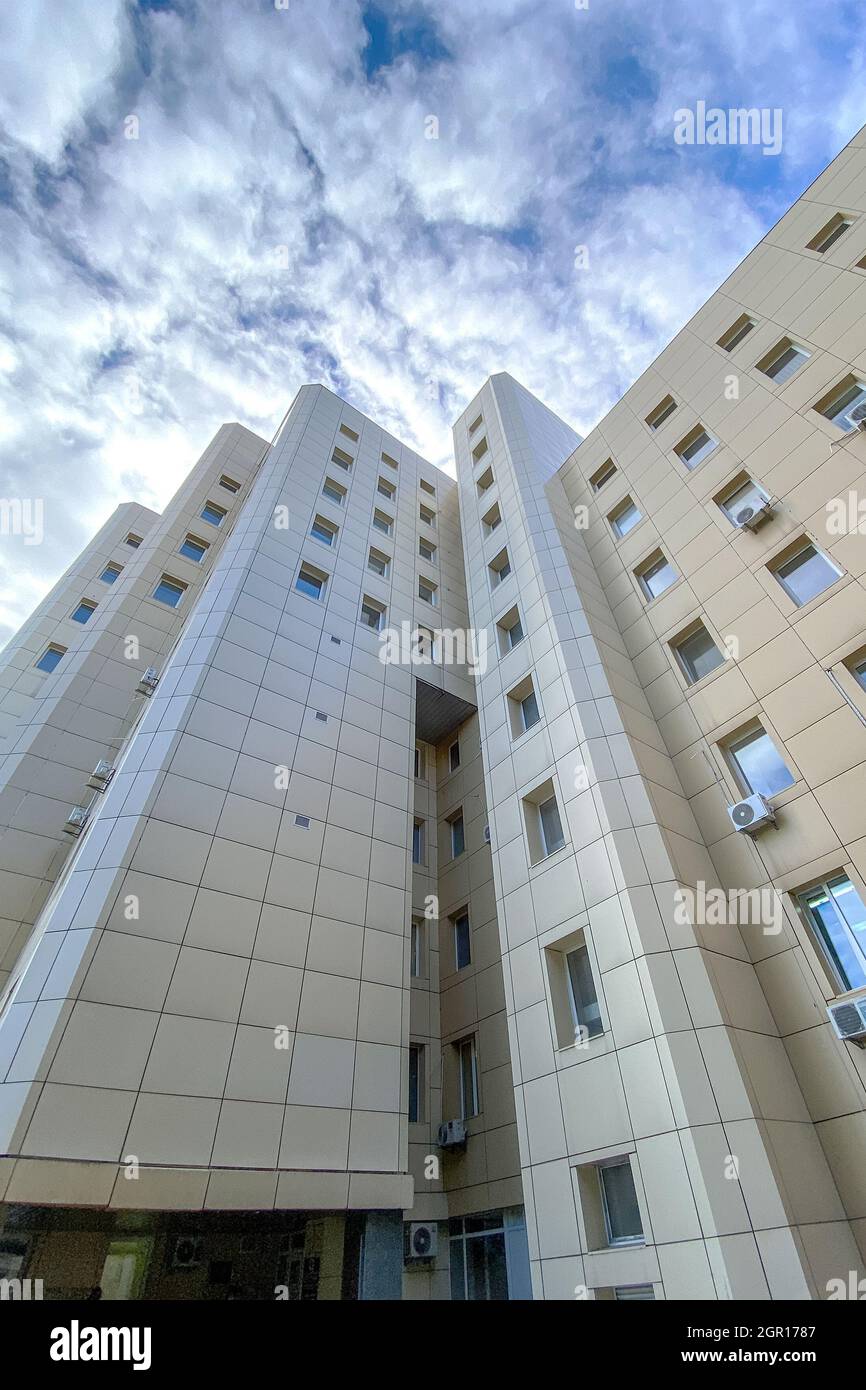 Außen legere, urbane, moderne Bürohochhaus-Architektur mit Himmelswolken. Rauschen, Filmkörnung als künstlerische Wirkung, weicher Fokus. Outdoo Stockfoto