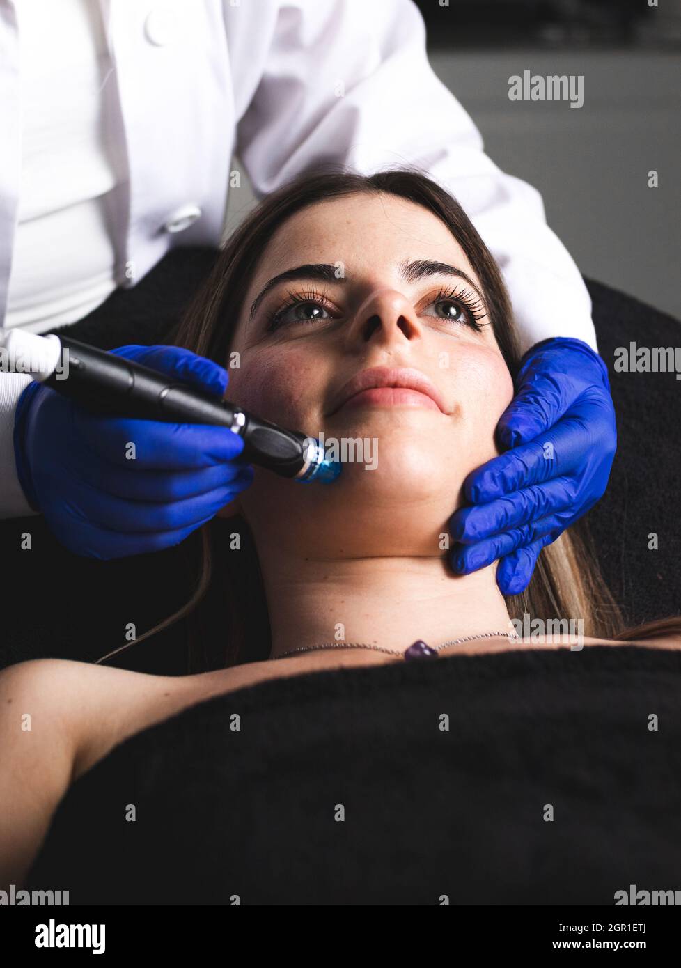 Eine junge Frau, die ihr Gesicht in einer ästhetischen Klinik putzt Stockfoto