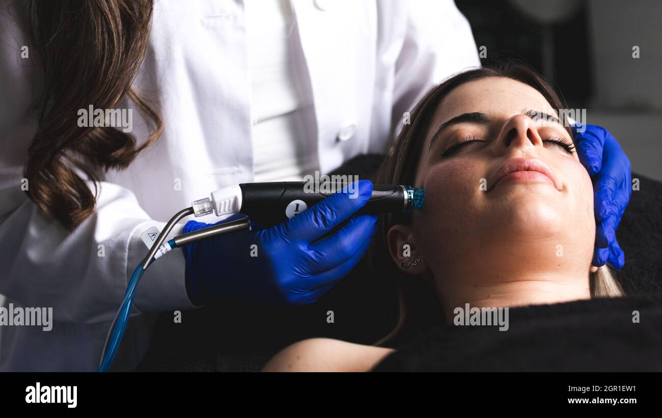 Eine junge Frau, die ihr Gesicht in einer ästhetischen Klinik putzt Stockfoto