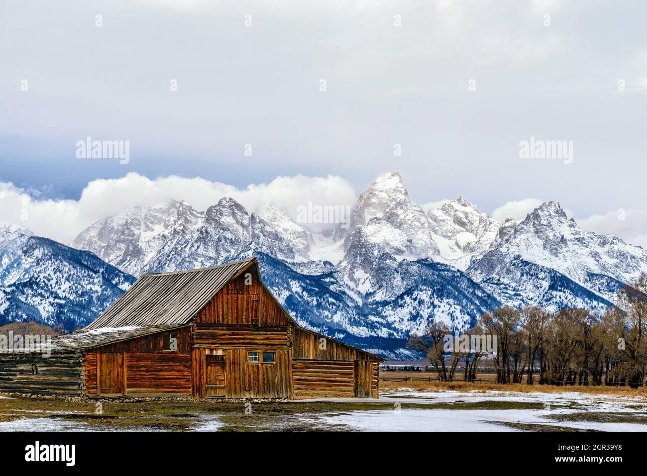 T.A. Molton's historische Scheunenstruktur mit der schneebedeckten Teton Range im Hintergrund Stockfoto