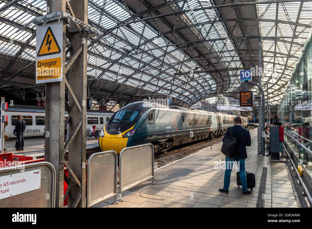 Geschäftsmann wartet auf einen Zug am Bahnhof Liverpool Lime Street, Liverpool, Merseyside, Großbritannien. Stockfoto