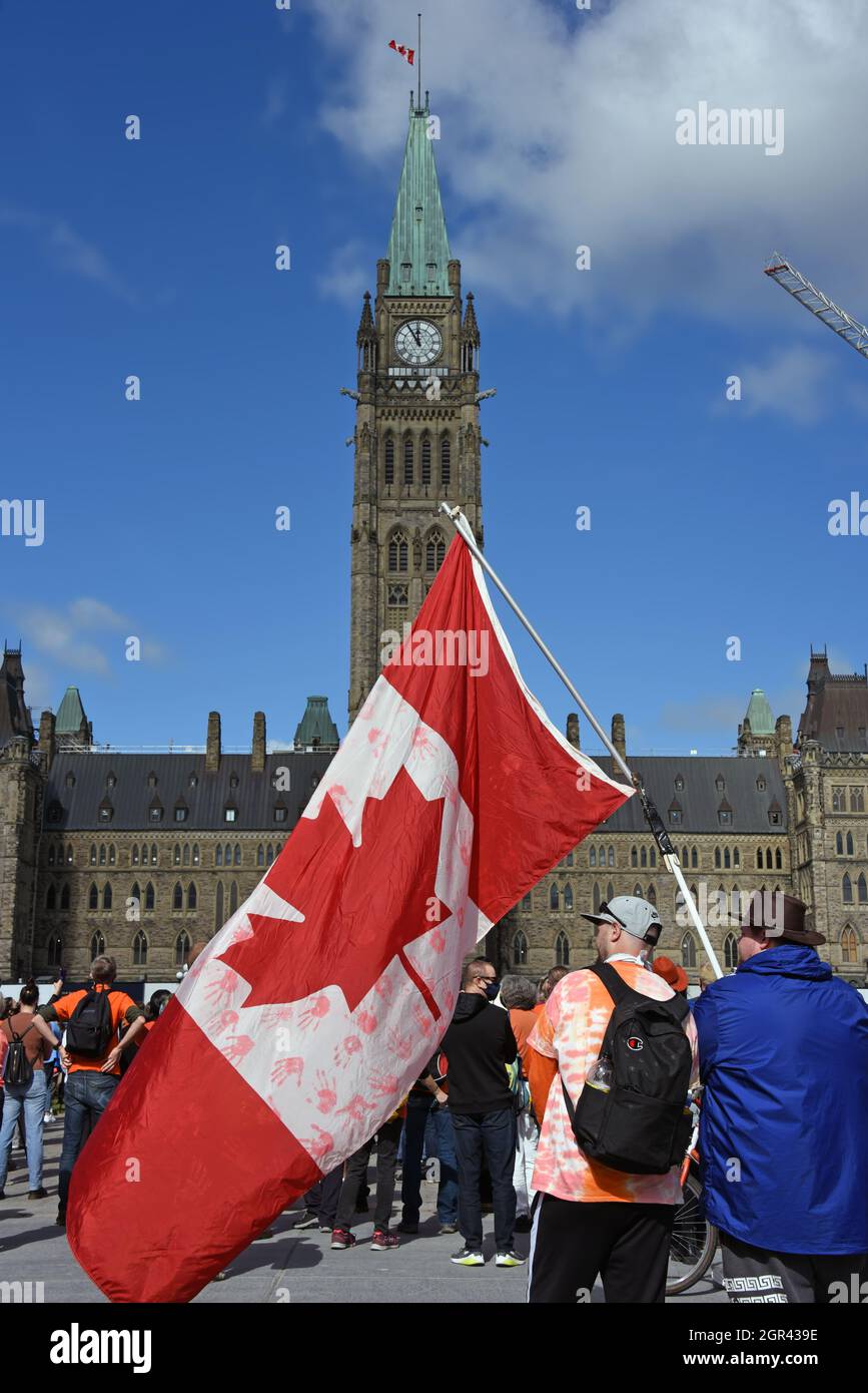 Ottawa, Kanada - 30. September 2021: Eine Menschenmenge versammelt sich auf dem Parliament Hill, um am Nationalen Tag für Wahrheit und Versöhnung, alias Orange Shirt Day, teilzunehmen. Der Tag wurde 2021 erstmals von der kanadischen Regierung als gesetzlicher Feiertag ausgerufen, angesichts der Enthüllungen von über 1,000 unmarkierten Gräbern in der Nähe ehemaliger Wohnschulgelände. Stockfoto