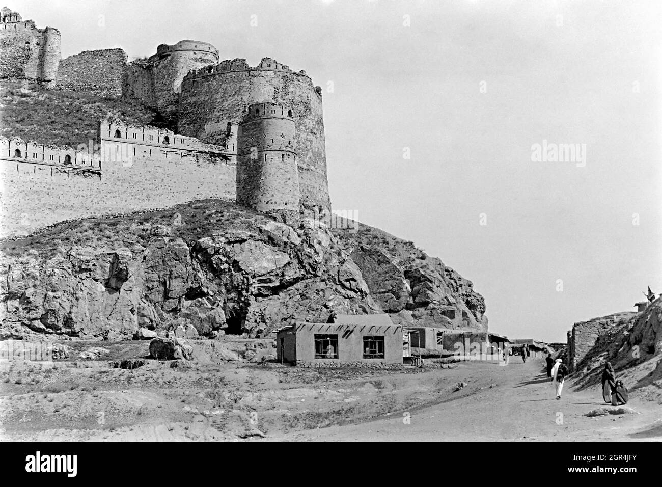 KABUL, AFGHANISTAN. April 1988. Afghanen gehen an den Ruinen des alten 5. Jahrhunderts vorbei, der Festung Bala Hissar auf dem Berg Kuh-e-Sherdarwaza am 14. April 1988 in Kabul, Afghanistan. Stockfoto