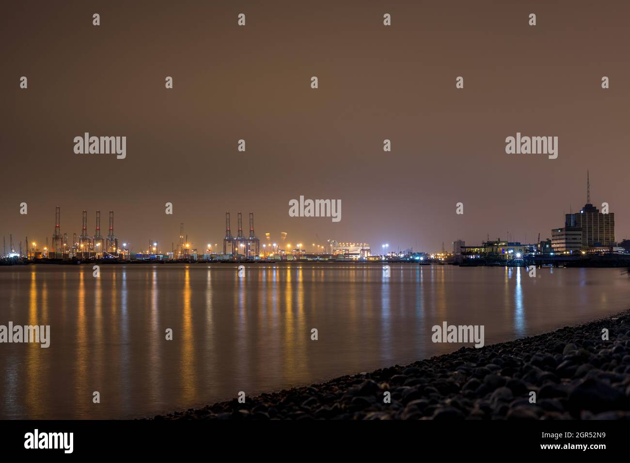 Wunderschöne Nachtansicht des Südpiers von Callao, der sich in den Ozean in Lima, Peru, spiegelt Stockfoto