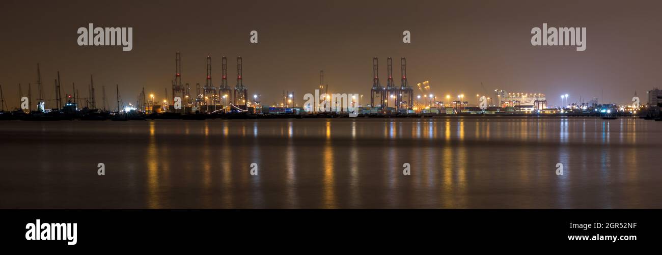 Schönes Nachtpanorama des Südpiers von Callao, das sich in den Ozean in Lima, Peru, spiegelt Stockfoto