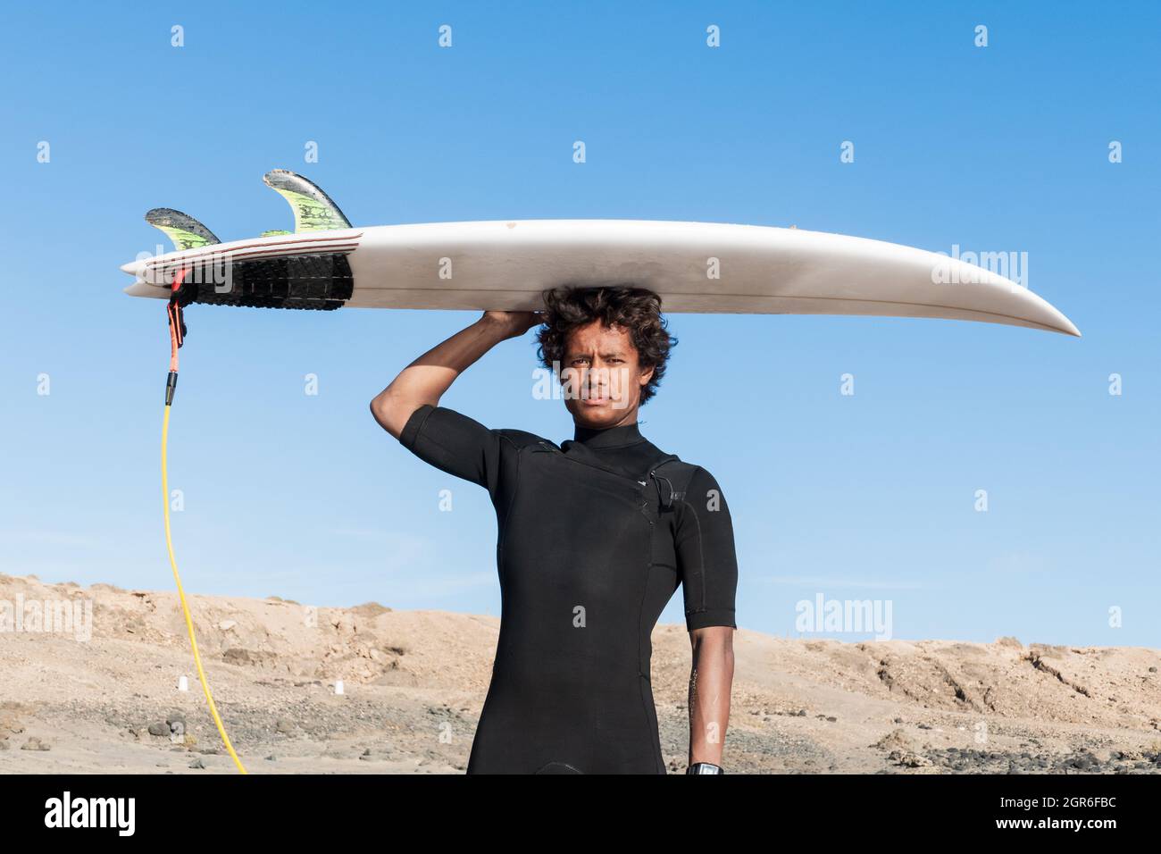 Junge afrikanische madagassische sportliche Surfer Porträt hält Shortboard tragen kurze schwarzen Neoprenanzug Stockfoto