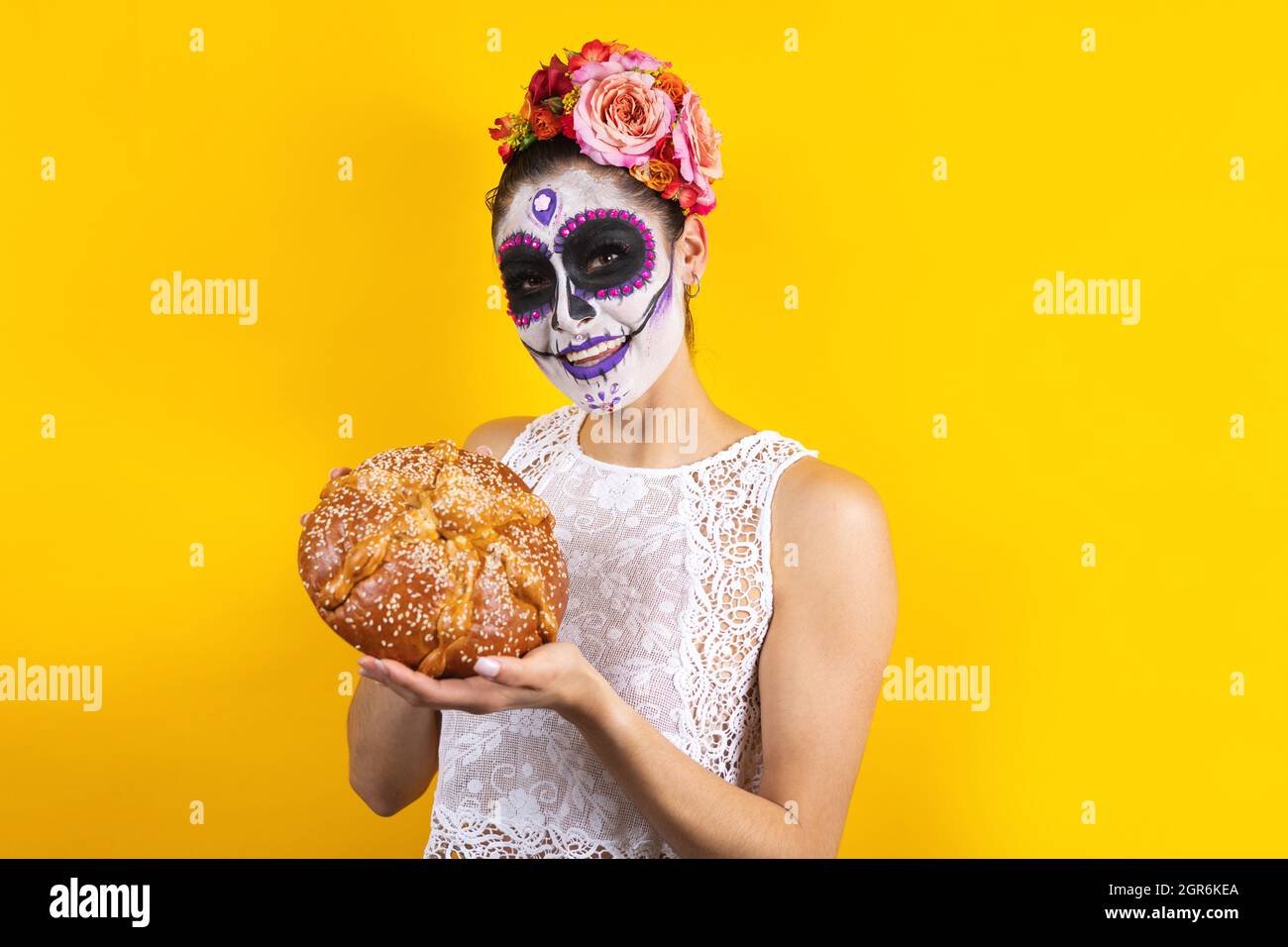 Mexikanische Catrina, Porträt einer jungen lateinischen Frau mit mexikanischem Hojaldra traditionellem Brot, Halloween-Party in Mexiko Stockfoto