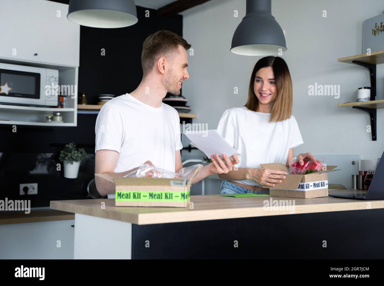 Happy Caucasian White Couple Auspacken Online Nach Hause Lieferung Von Lebensmitteln. Feld. Dienstleistungen. Menü-Set Stockfoto