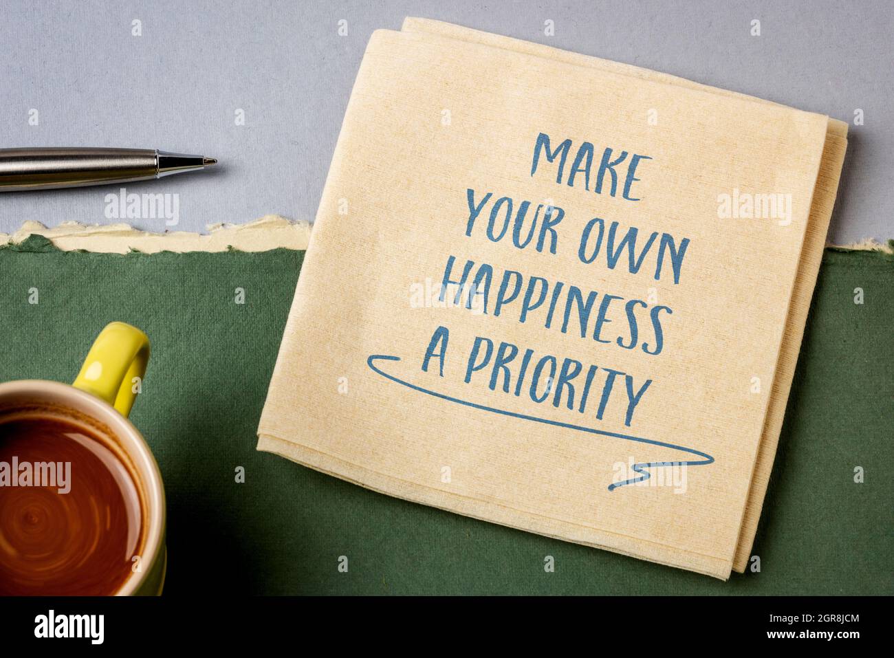 Machen Sie Ihr eigenes Glück Priorität inspirierende Beratung oder Erinnerung, Handschrift auf einer Serviette mit einer Tasse Kaffee, persönliche Entwicklung Konzept Stockfoto