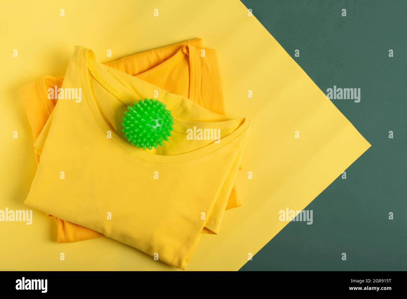 Wäscheball Für Waschmaschine Und Gelbe Hemden Auf Geometrischem Hintergrund. Pflege Der Kleidung Stockfoto