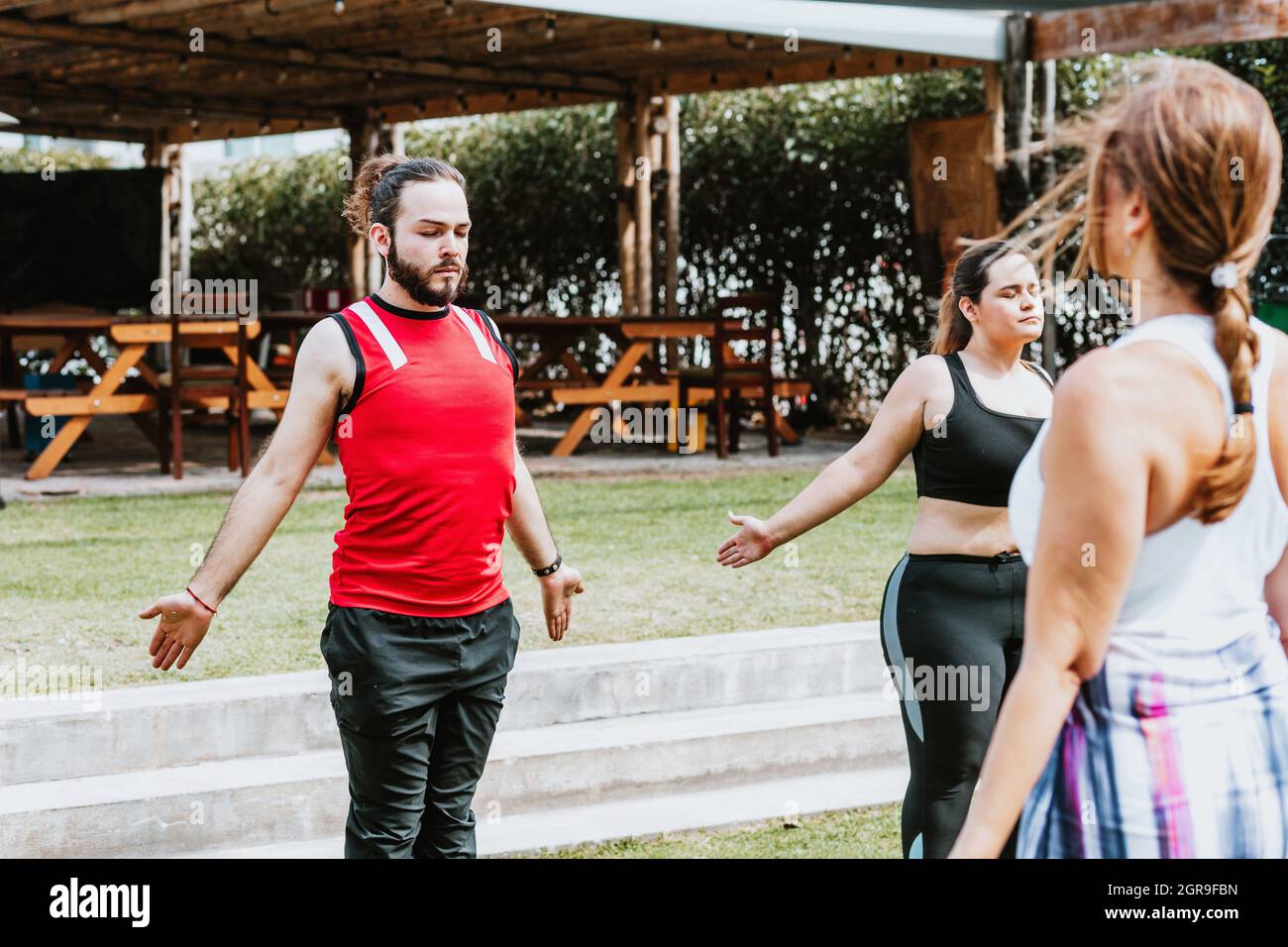 Junge lateinamerikaner im Yoga-Kurs machen Atemübungen mit einem Lehrer im Freien in Mexiko-Stadt Stockfoto
