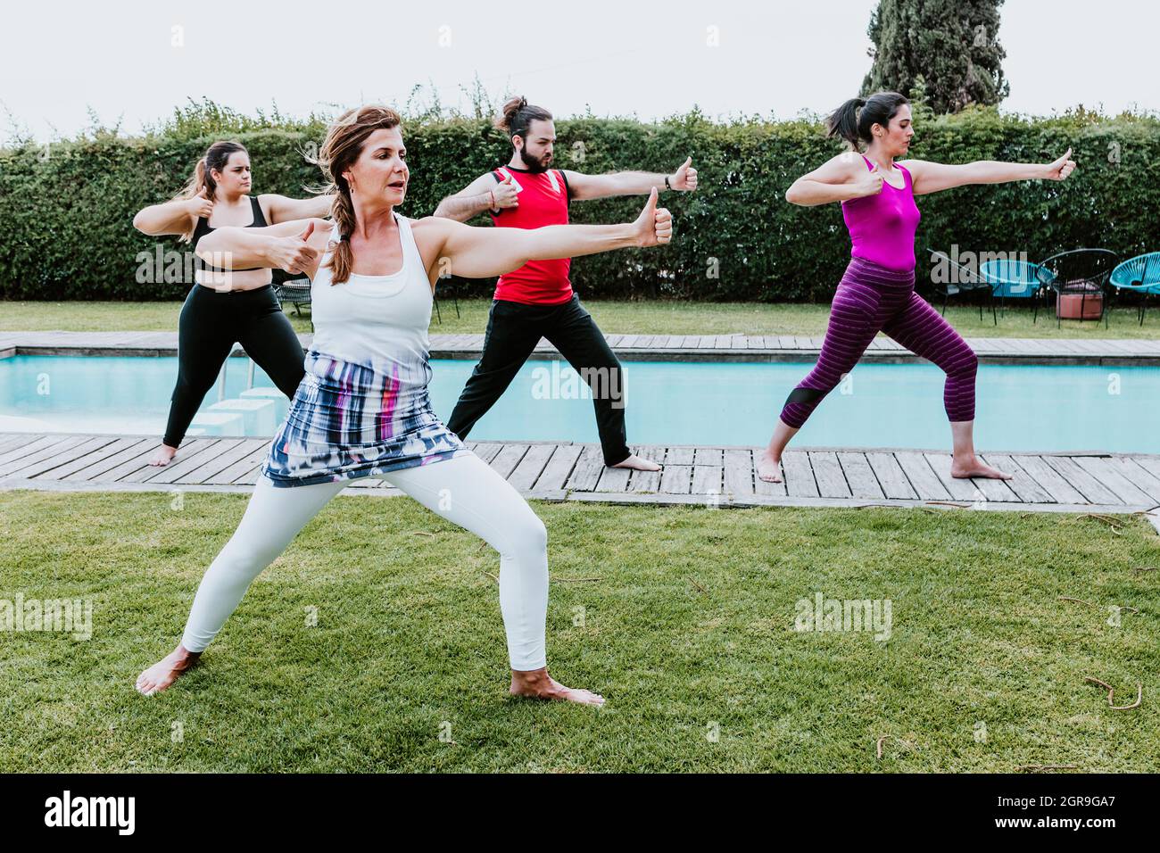 Hispanische Menschen üben die Bogenschützenpose im Yoga im Freien in Lateinamerika Stockfoto