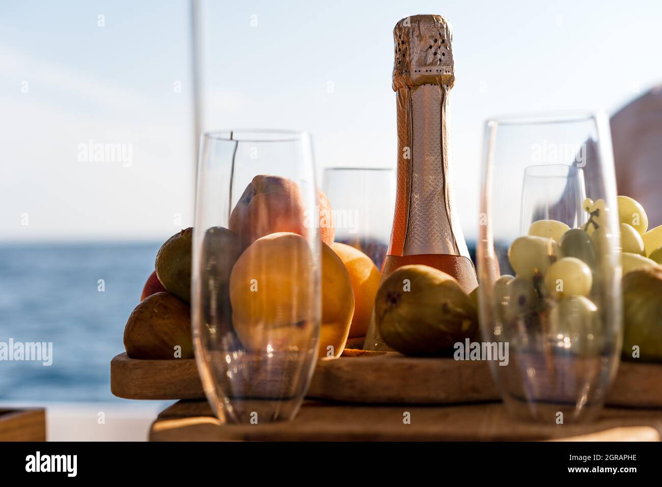 Obstschale und Flasche Champagner für ein romantisches Date auf einer Yacht Stockfoto