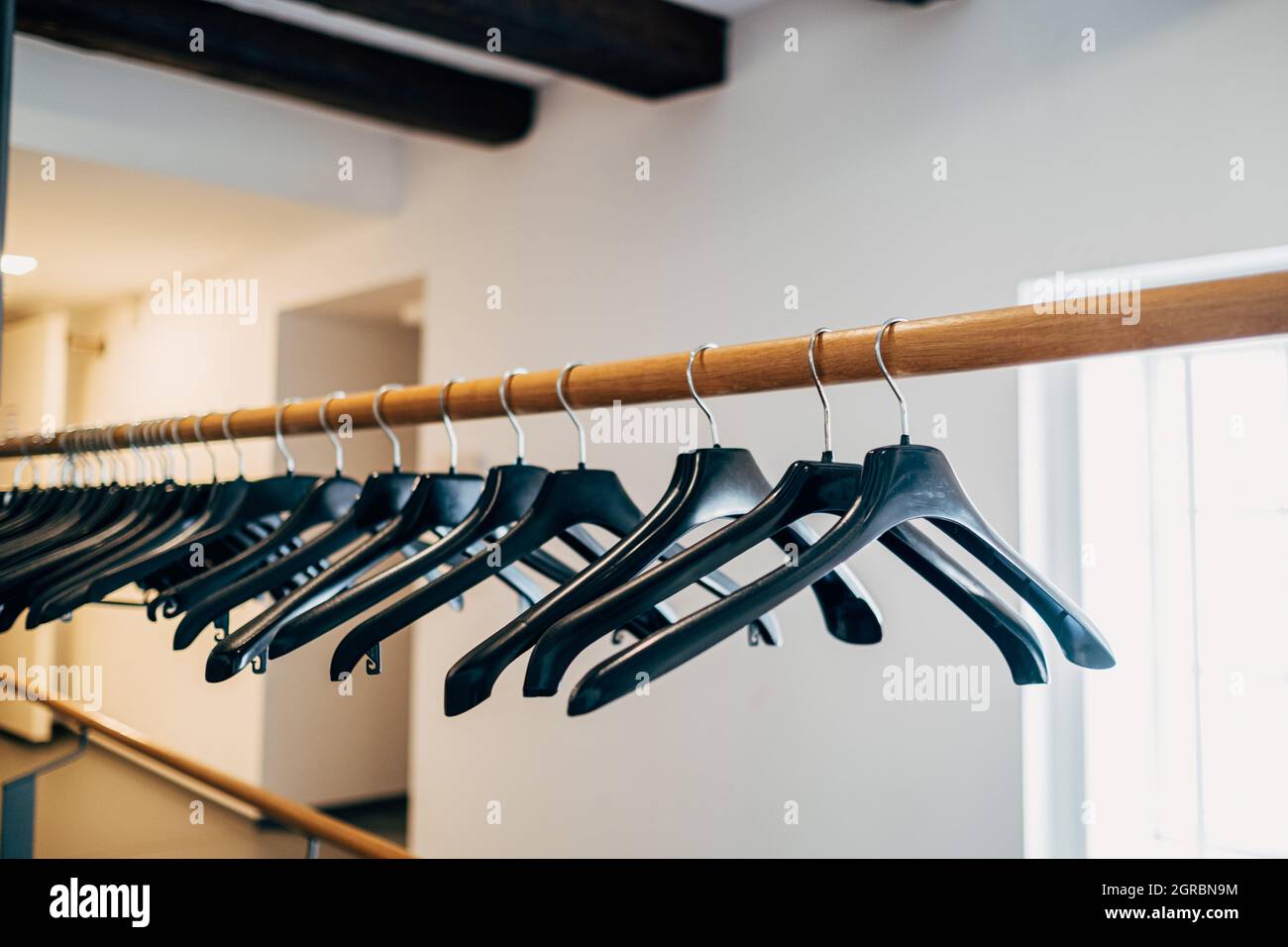 Schwarzer Kleiderbügel Aus Kunststoff An Der Garderobe Stockfotografie -  Alamy