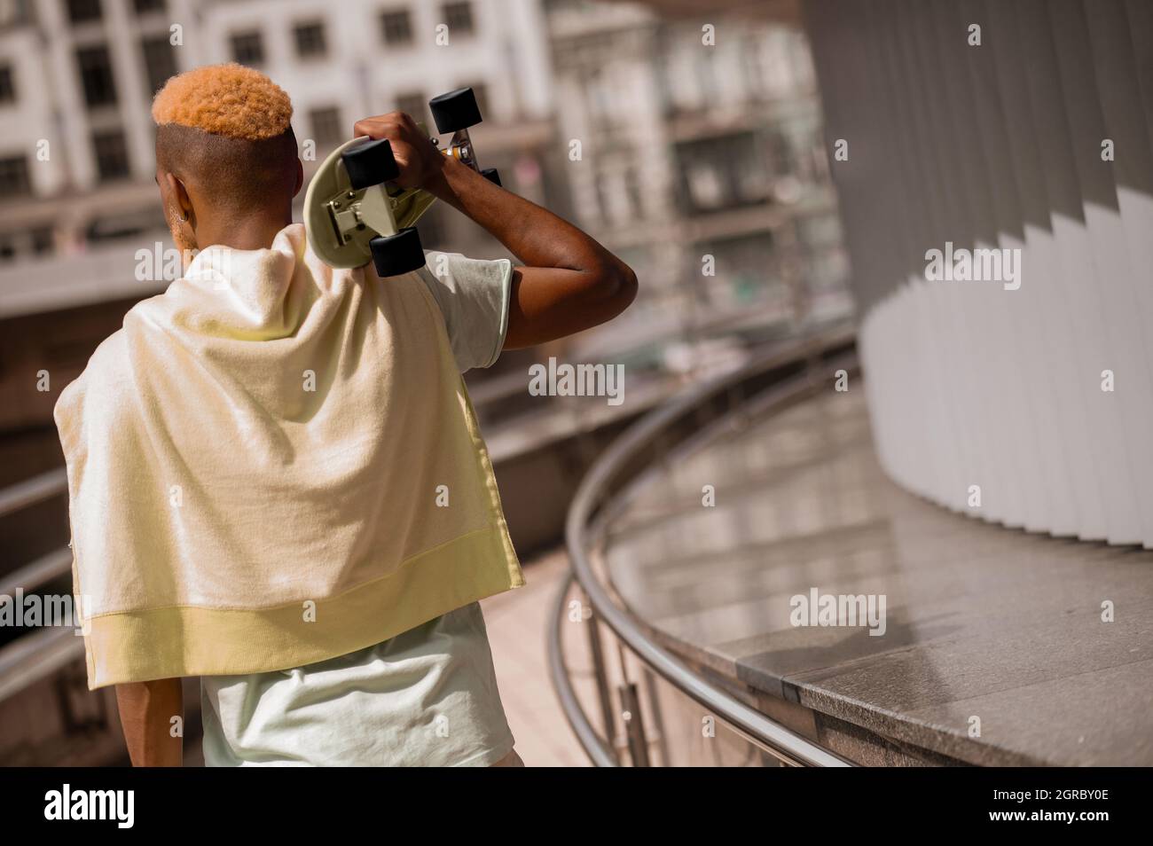 Bärtiger junger dunkelhäutiger Mann mit einem Skateboard Stockfoto