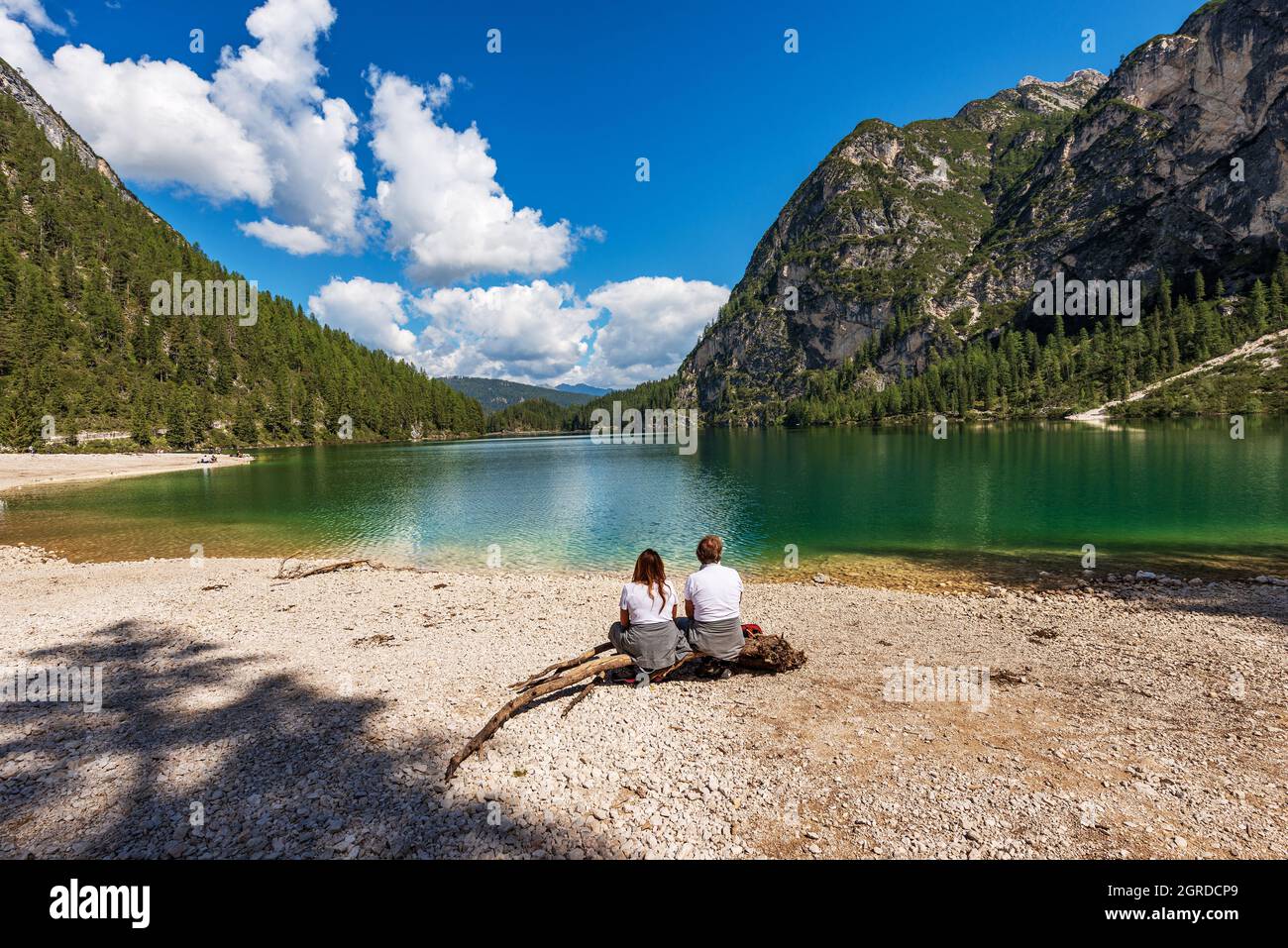 Zwei Personen entspannen sich am Ufer des Pragser Wildsees oder des Pragser Sees. Gipfel des Sasso del Signore, Dolomiten, Trentino-Südtirol, Bozen, Italien. Stockfoto