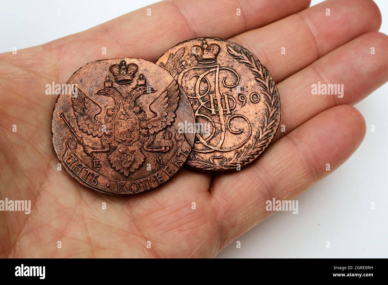 Zwei alte russische Kupfermünzen aus dem 18. Jahrhundert in der Palme Stockfoto