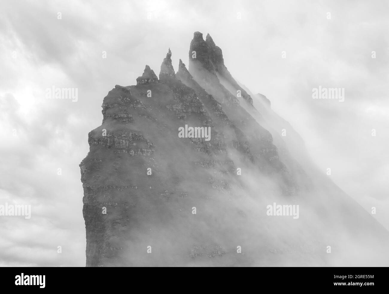 Mystisch neblige Landzungenlandschaften entlang der Küste von Vagar Island, Färöer Inseln. Die felsigen Gipfel der Insel Tindholmur (in der Nähe von Mykines), umhüllt von dichtem Nebel Stockfoto