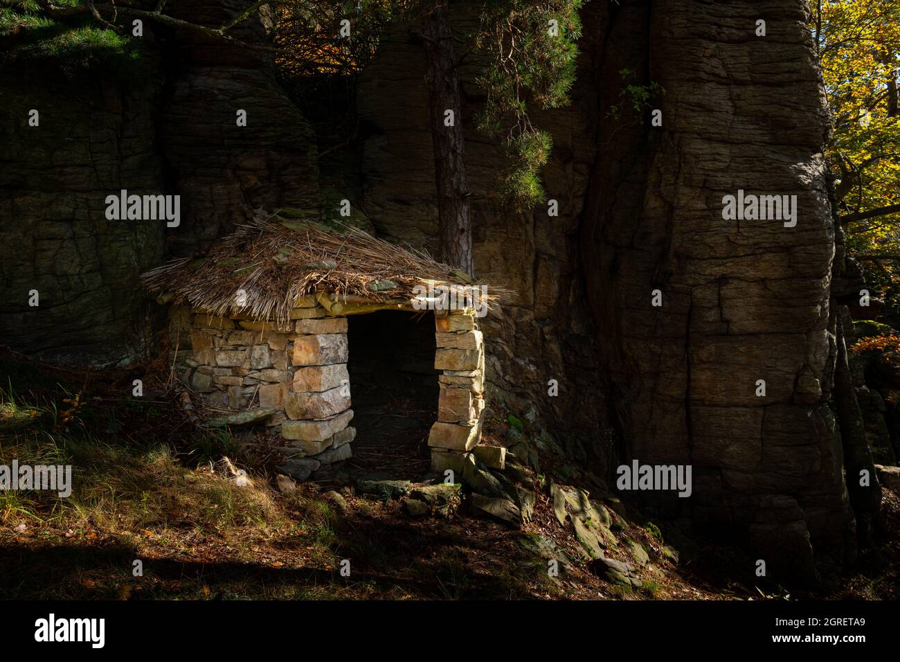Kleine Steinhütte mitten im Wald, sonniger Herbsttag Stockfoto