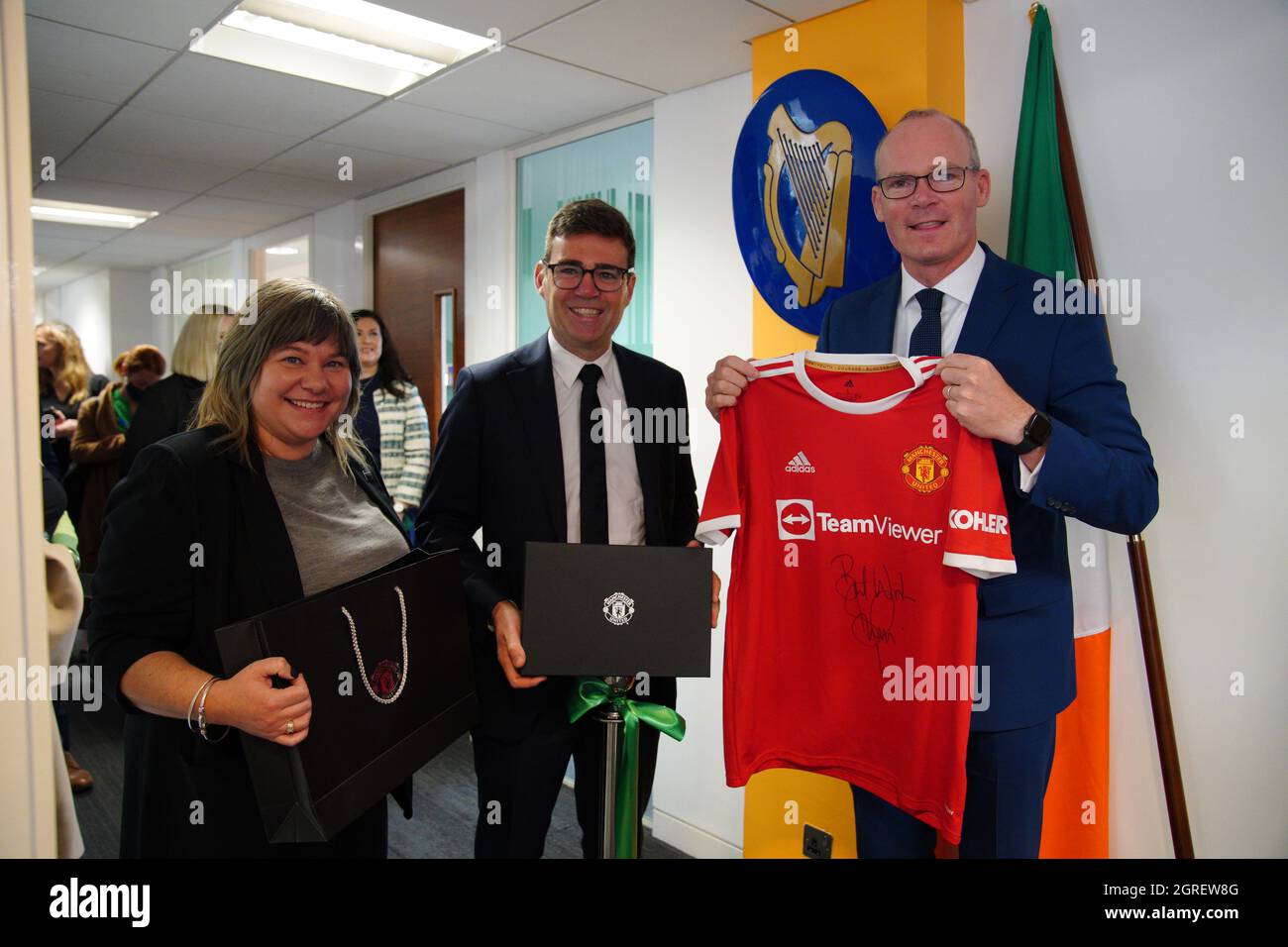 Außenminister Simon Coveney wurde bei der offiziellen Eröffnung des irischen Generalkonsulats für Nordengland von der Ratsvorsitzenden von Stockport, Elise Wilson, und dem Bürgermeister von Greater Manchester, Andy Burnham, in Manchester ein signiertes Trikot des Denis Irwin Manchester United FC überreicht. Bilddatum: Freitag, 1. Oktober 2021. Stockfoto