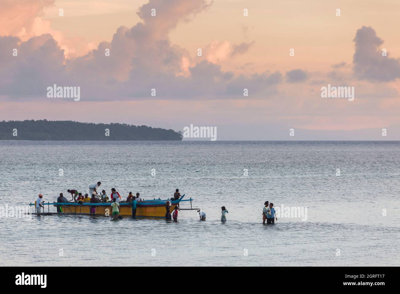 Indonesien, Papua, Insel Biak, Strand von Bosnik, Passagiere, die aus einem Auslegerkanu aussteigen Stockfoto