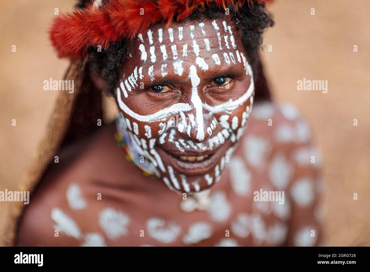 Indonesien, Papua, Stadt Wamena, Porträt einer jungen Dani-Frau, die weißes Make-up auf Gesicht und Körper trägt. Baliem Valley Cultural Festival, jedes Jahr im August kommen Stämme zusammen, um uralte Kriegsszenen aufzuführen, Parade und Tanz in traditioneller Kleidung Stockfoto