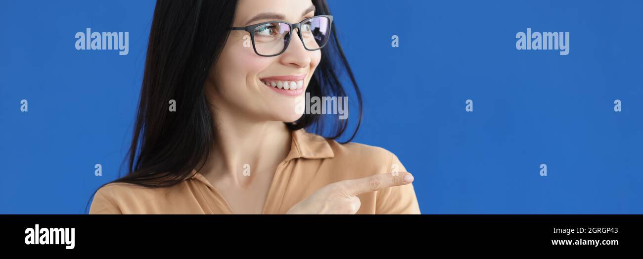 Porträt einer charmanten lächelnden Frau mit Richtungsgeste Stockfoto